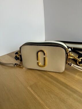 Sac bandoulière Marc Jacobs Snapshot – couleur crème avec strap rayé.